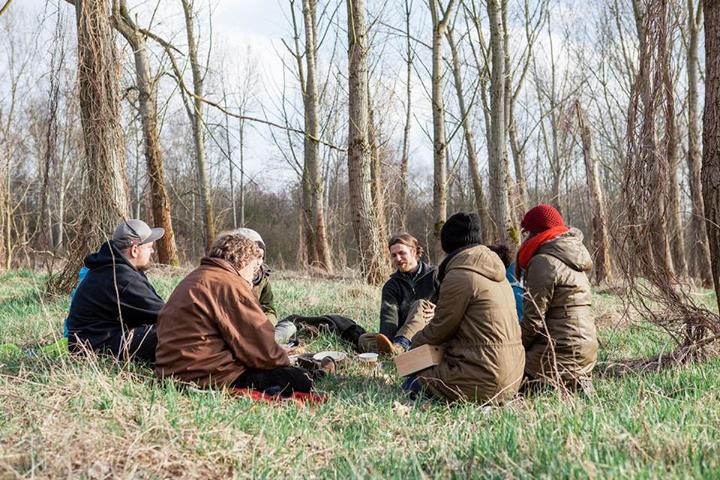 Der Kreis von Teilnehmern versammelt sich nach einer Übung zur Reflexion im Wald